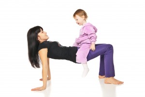 Mother with the baby doing exercises over white